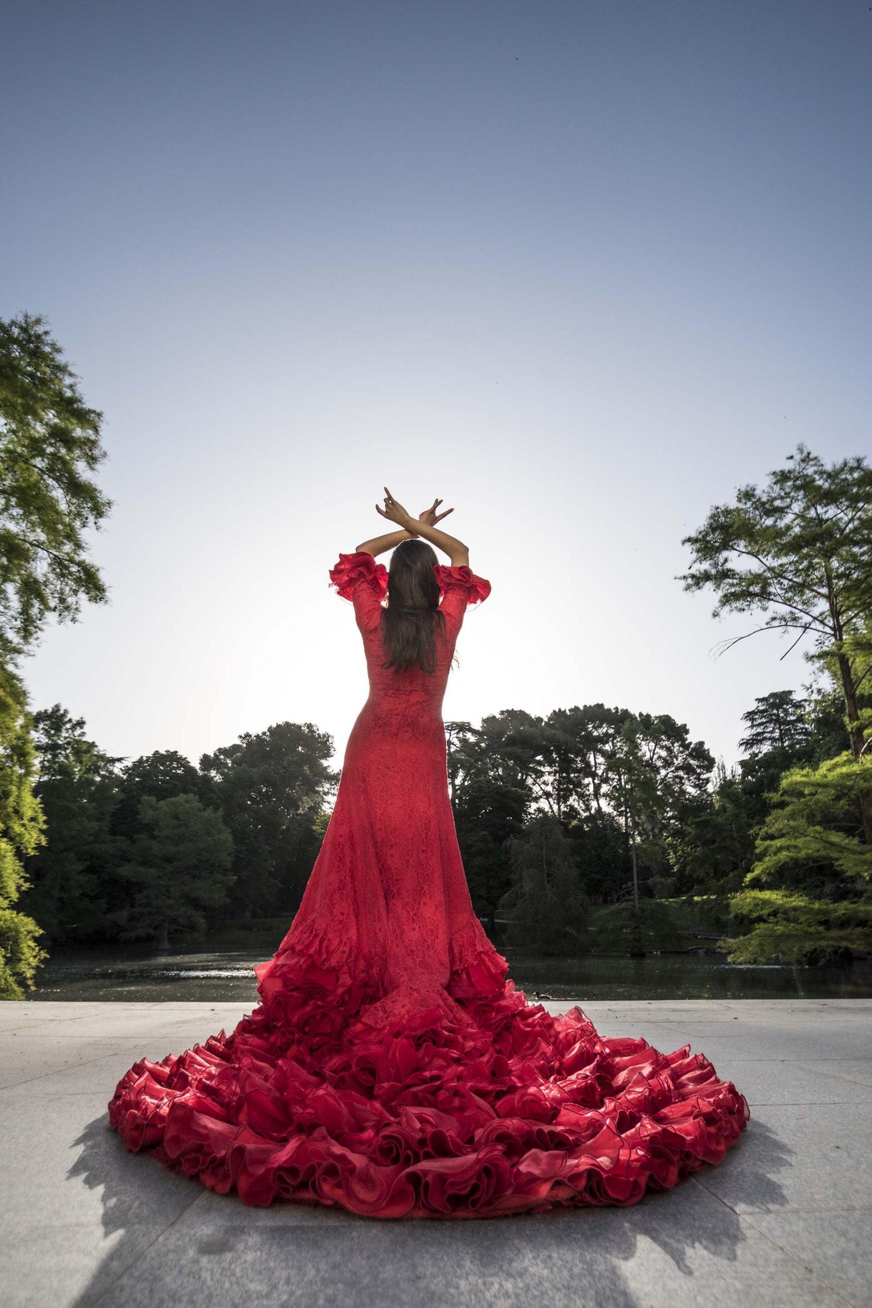 Back view of woman dressed in red dancing flamenco on a terrace planchado traje vestido sevillana flamenca planchado trajes regionales vestido talaverana
